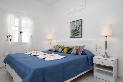 Una cama con sábanas y almohadas azules. en GARDEN HOUSE APARTMENT, en Pitsidia