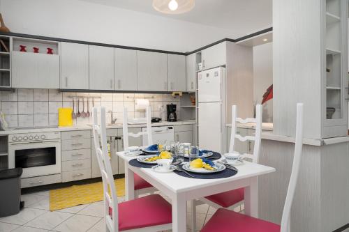 una cocina con una mesa blanca con platos de comida. en GARDEN HOUSE APARTMENT, en Pitsidia