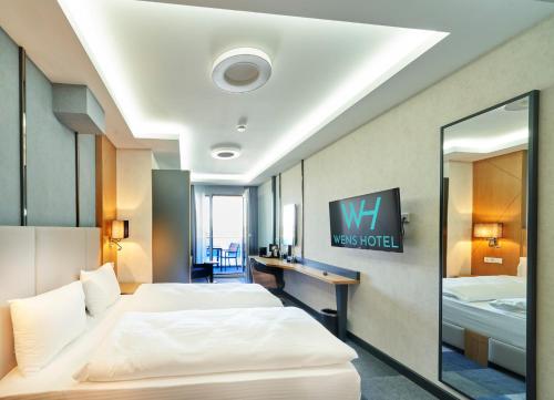 una camera d'albergo con due letti e uno specchio di WENS Hotel a Magonza