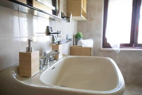 um lavatório branco numa casa de banho com uma janela em B&B Casa Gioconda em Monte Vidon Combatte