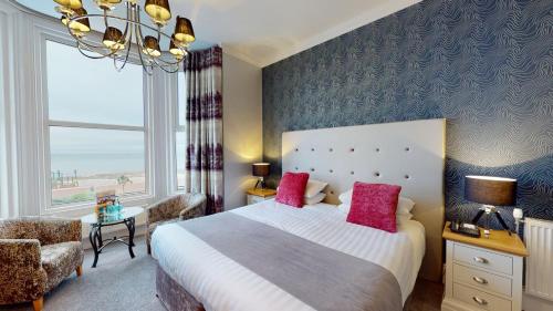 a bedroom with a large bed and a large window at Tynedale Hotel in Llandudno