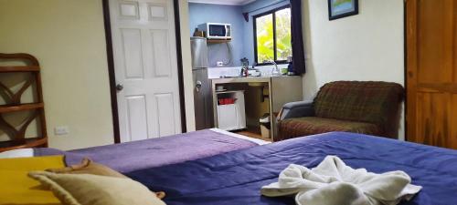een slaapkamer met een bed, een stoel en een wastafel bij Granja Agua Azul.A/C WiFi,2 Camas, Rio, jardines. in Fortuna