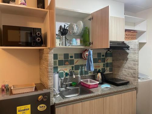 a small kitchen with a sink and a microwave at INSPIRIA 1803 Studio Unit with Balcony beside Abreeza Mall Davao in Davao City