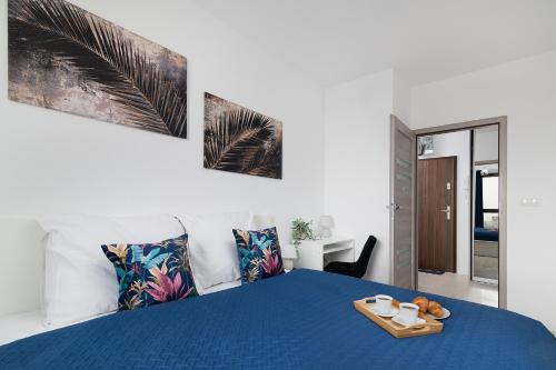 Un dormitorio con una cama azul y una bandeja. en Easy Rent- Metropolitan 75 Hala Globus, 24h Check-in, Zana, en Lublin