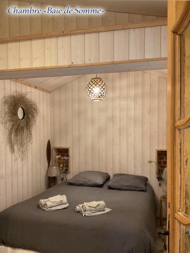 une chambre avec un lit avec deux serviettes dessus dans l'établissement La Ferme Bleue, Havre de paix de la Baie de Somme, à Pendé