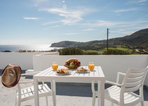 einen weißen Tisch mit Speisen und Getränken auf dem Balkon in der Unterkunft Sarantis Suites & Apartments in Provatas