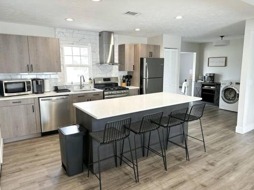 a kitchen with a white counter and chairs in it at Modern 3 bed 1 bath Home near downtown and UNL Lincoln in Lincoln