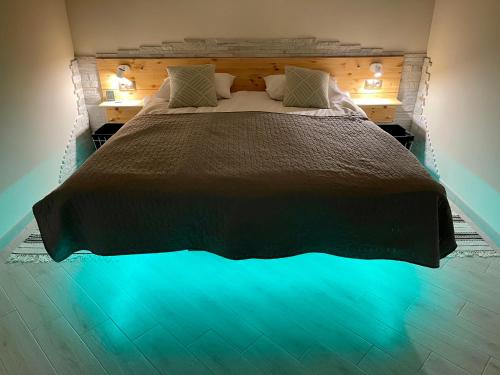 a bedroom with a large bed with blue illumination at Апартаменти Underground&SPA in Lviv