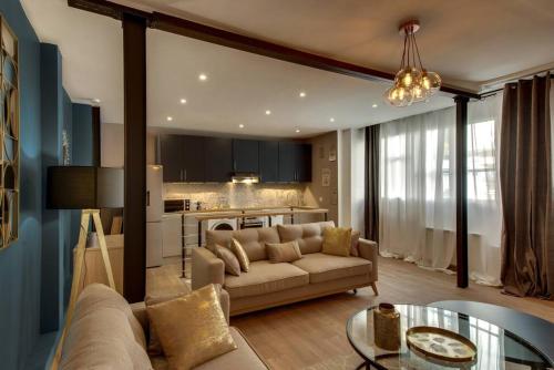 ein Wohnzimmer mit einem Sofa und einem Tisch in der Unterkunft Beautiful Triplex in the Center of Paris in Paris