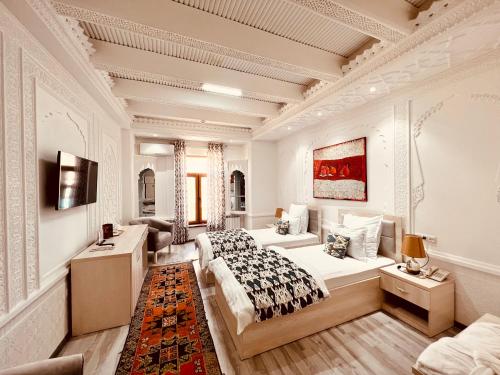 a bedroom with two beds and a couch at Miniature Boutique Hotel in Bukhara