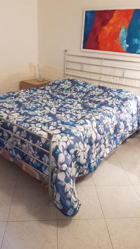 a bed with a blue and white comforter in a room at La Casa Sul Porto in Brindisi