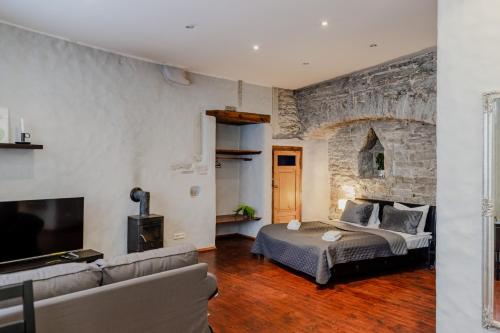 - un salon avec un lit et un mur en pierre dans l'établissement Dream Stay - Old Town City Wall Studio Apartment, à Tallinn