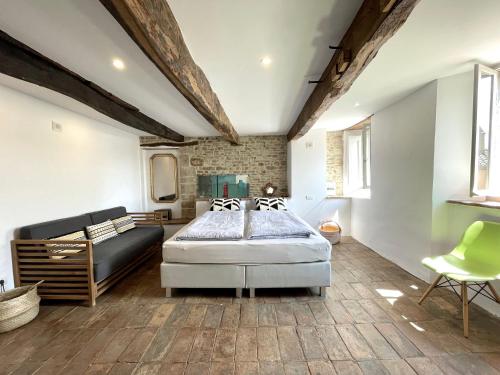 um quarto com uma cama e um sofá em Palazzo Minzoni em SantʼIppolito