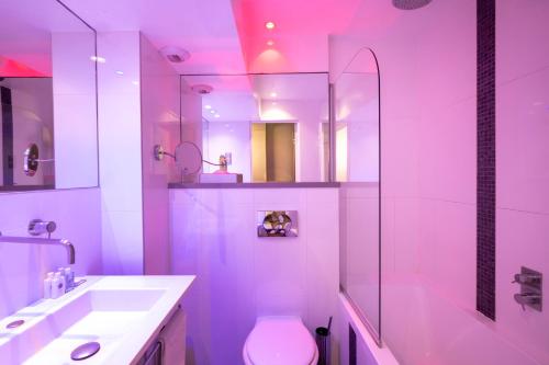 uma casa de banho com um lavatório, um WC e um chuveiro em ATN Hôtel em Paris