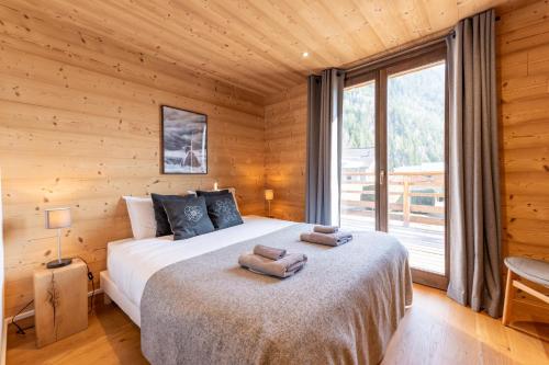 a bedroom with a bed and a large window at Chalet les 3 cerfs in Les Contamines-Montjoie