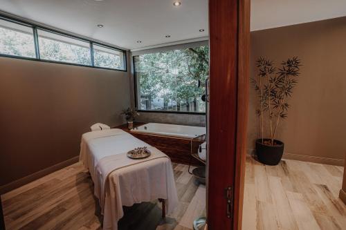 a room with a bath tub and a table with a table sidx sidx at La Urumpta Hotel, AKEN MIND in Río Cuarto