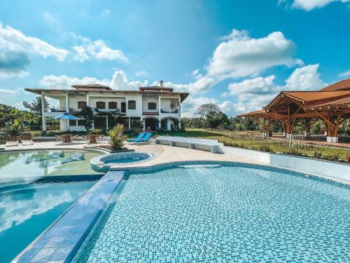 a large swimming pool in front of a house at Casona Montanesa Quindío eje cafetero in Montenegro