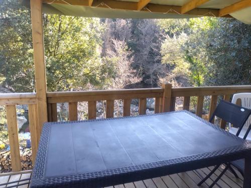 a table and chairs on a deck on a porch at Camping Les Eaux Vives in Vero
