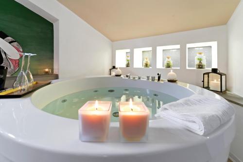 a bathroom with a tub with candles in it at Ukiyo Suites And Rooms in Cagliari