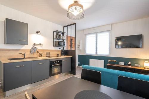 une cuisine avec une table et un canapé bleu dans l'établissement Appartement 1 chambre centre Boulogne-sur-Mer, à Boulogne-sur-Mer