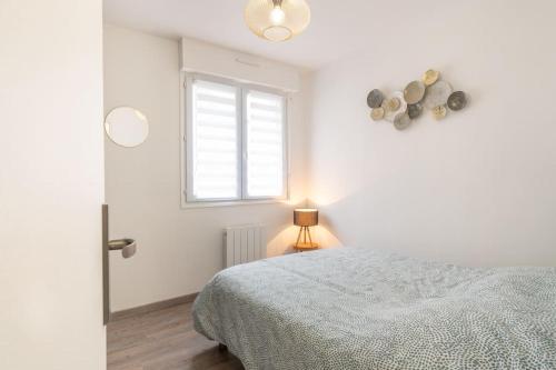 une chambre blanche avec un lit et une fenêtre dans l'établissement Appartement 1 chambre centre Boulogne-sur-Mer, à Boulogne-sur-Mer