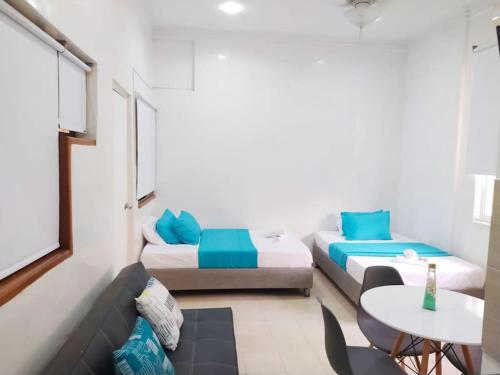 um pequeno quarto com duas camas e uma mesa em apartamento centro histórico 303-1 em Cartagena das Índias