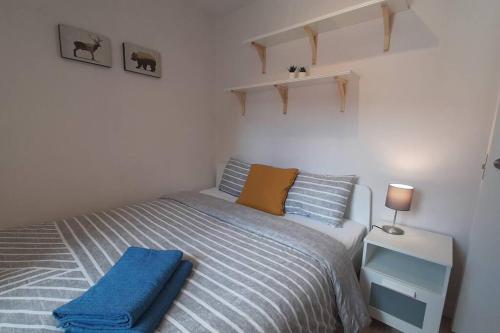 Un dormitorio con una cama con una toalla azul. en Apartamento moderno al pie de los Pirineos, en Sabiñánigo