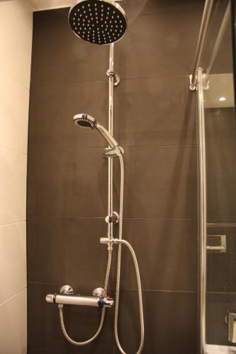 une douche avec pommeau de douche dans une salle de bain dans l'établissement B&B Keizers Canal, à Amsterdam