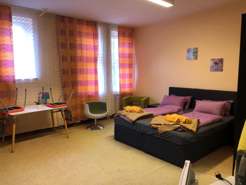 a bedroom with a bed and a desk and window at HOSTEL Wesendorf Residenz in Wesendorf