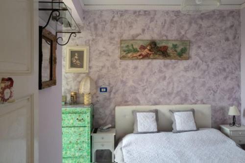 um quarto com uma cama e um quadro na parede em Villa Gaia em Taormina