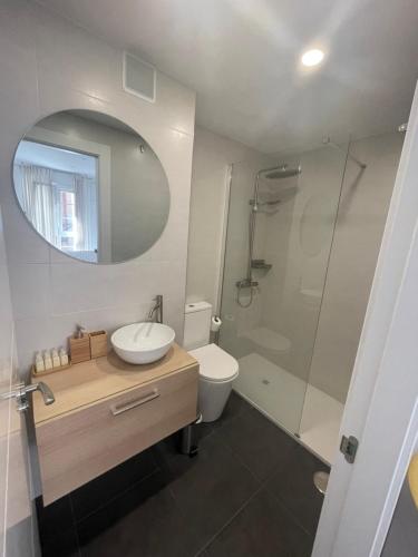 een badkamer met een toilet, een wastafel en een douche bij Apartamento Playa San Lorenzo Garaje opcional in Gijón