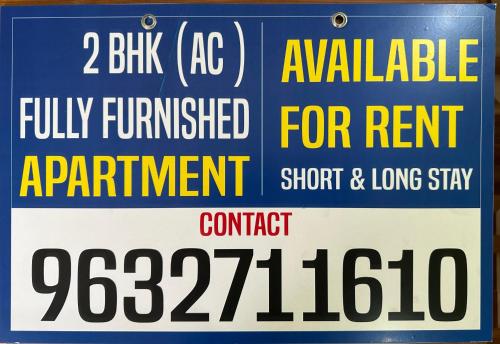 a sign that is on the side of a building at ISHRA SERVICE APARTMENTS in Dharmastala