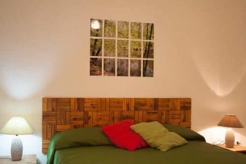 een bed in een slaapkamer met 2 lampen en een schilderij bij Buona Onda in Marsala