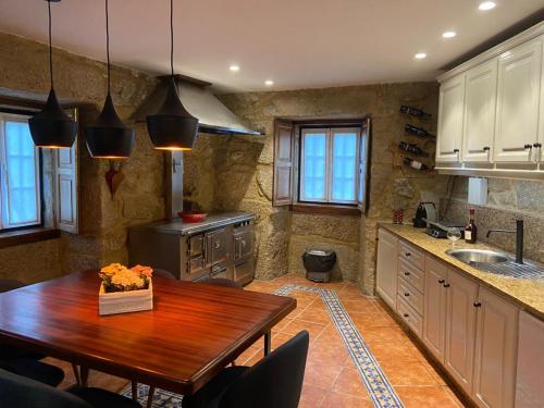 a kitchen with a wooden table and a sink at Casa Posto da Guarda Fiscal in Melgaço