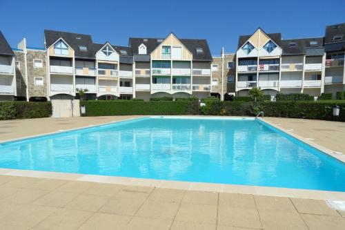 une piscine devant un grand immeuble d'appartements dans l'établissement REF 032 Studio pour 4 vue port Crouesty dans résidence avec piscine, à Arzon