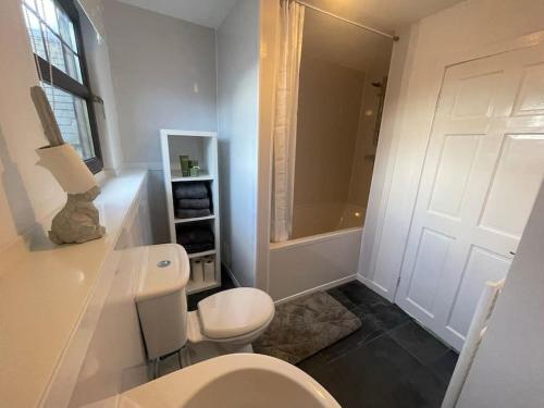a white bathroom with a toilet and a shower at Apartment in Coldstream in Coldstream