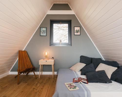 ein Wohnzimmer mit einem Sofa und einem Fenster in der Unterkunft Kanyar - Nordic Cabin in Zebegény