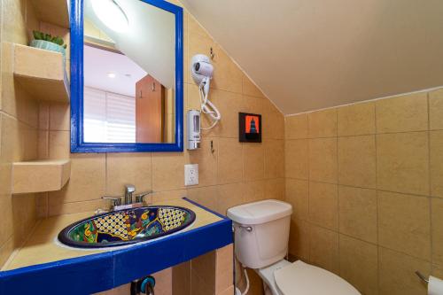 uma casa de banho com um lavatório, um WC e um espelho. em Lofts San Ángel em Cidade do México