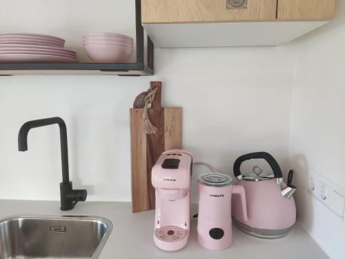 a kitchen counter with a sink and pink appliances at de Klaproos in Noordgouwe
