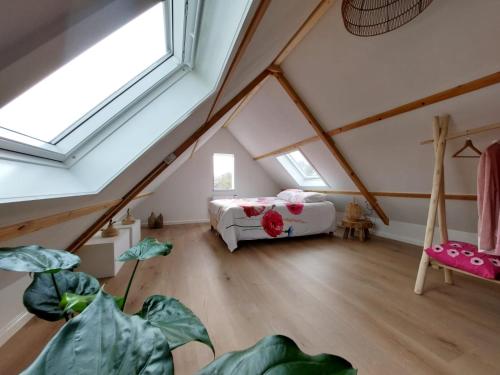 ein Schlafzimmer mit einem Bett im Dachgeschoss in der Unterkunft de Klaproos in Noordgouwe