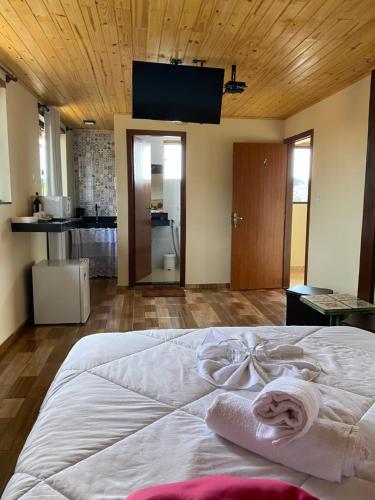 a bedroom with a large bed with towels on it at Suíte Aconchego Mineiro in Ouro Preto