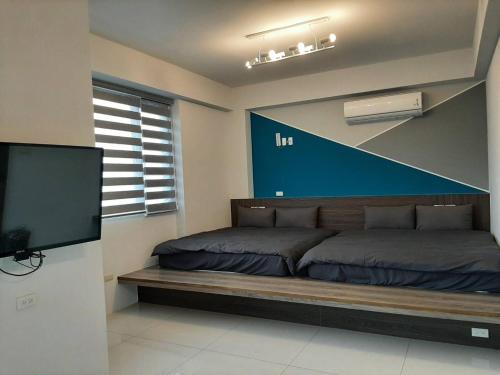 1 dormitorio con 2 camas y TV de pantalla plana en 秧月民宿, en Hsia-san-chieh
