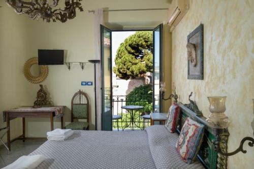 um quarto com uma cama e vista para um jardim em Villa Gaia em Taormina