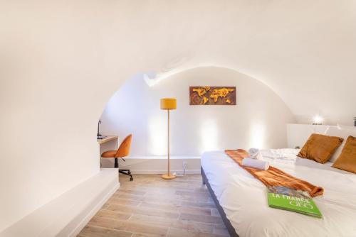 - une chambre blanche avec un lit et un bureau dans l'établissement Sainte Baume - Patio - Linge de qualité - Fibre - Confort - Cœur de Ville, à Gardanne