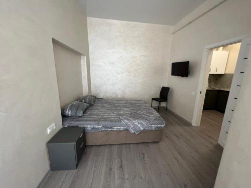 ein Schlafzimmer mit einem Bett und einem TV. in der Unterkunft Kulisha 2bedroom apartment near Opera House with balcony in Lwiw