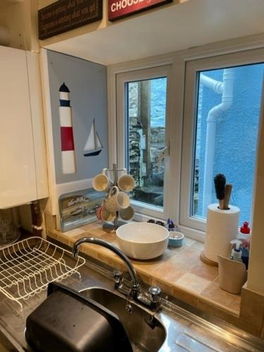 a kitchen counter with a sink and a window at Bryn Goleu, Mersey Street, Borth-y-Gest in Porthmadog