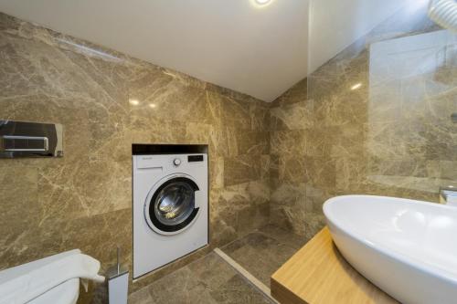 a bathroom with a washing machine and a sink at Gorgeous Flat with Sea View Jacuzzi in Antalya Kas in Kas