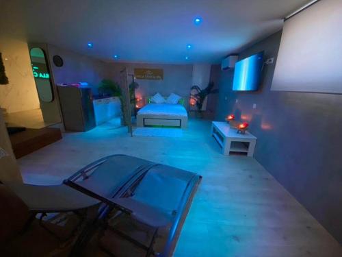 um quarto com uma cama com luzes azuis em Grande Villa cosy avec piscine, sauna & jacuzzi em Juvignac