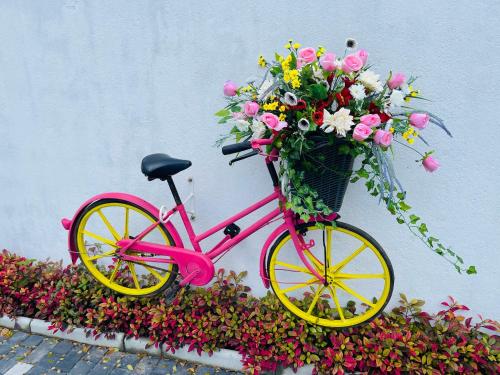 Una bicicleta rosa con una cesta llena de flores en Hotel willow lake, en Kurunegala