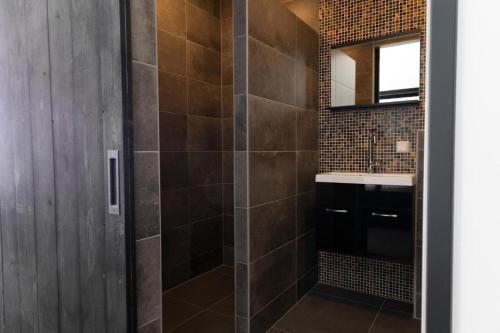 een badkamer met een douche, een wastafel en een spiegel bij Hotel Monnickendam in Monnickendam
